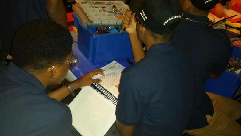 Jamaica College Robotic Team Making slight adjustments to the Engineering Notebook