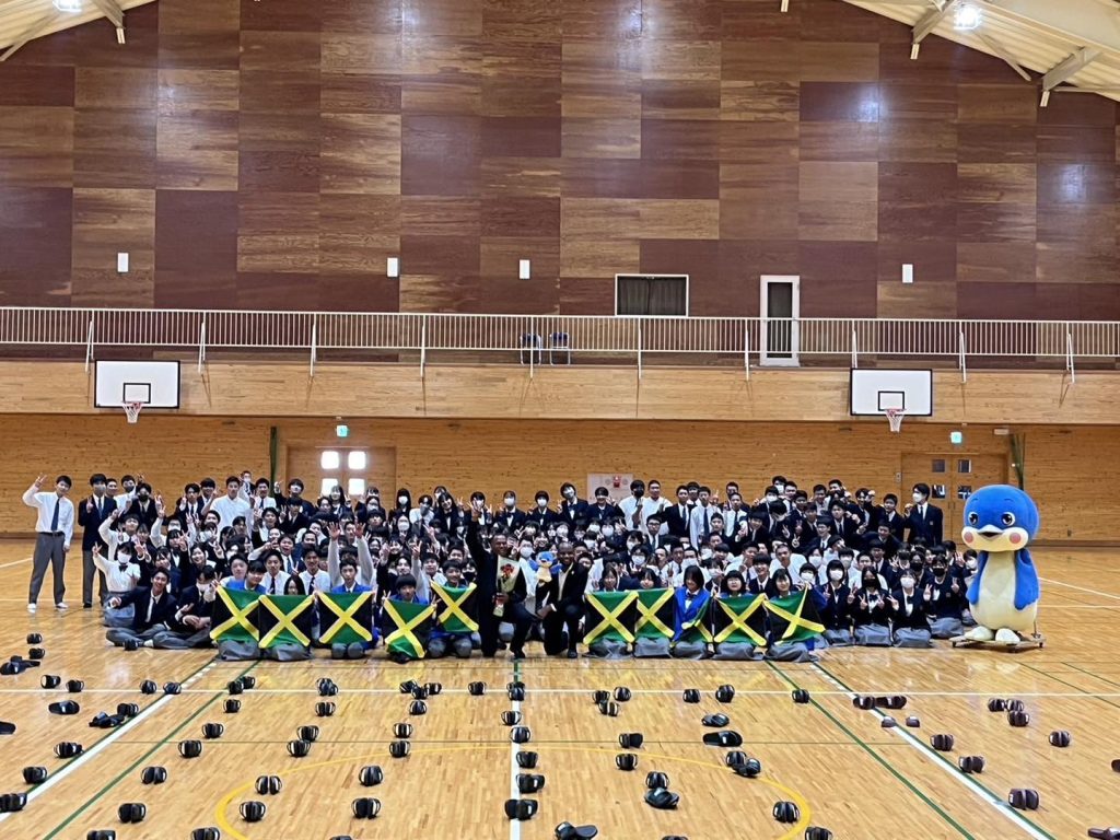 Jamaican Tenor Steve Higgins along with First Secretary of Jamaica' Embassy in Japan Sherdan Baugh pause to take a photo with over 200 students of the Iwami High School in Tottori prefecture in Japan. Higgins had just addressed the students and sung for them. The Iwami Brass band also played for this ceremony.

