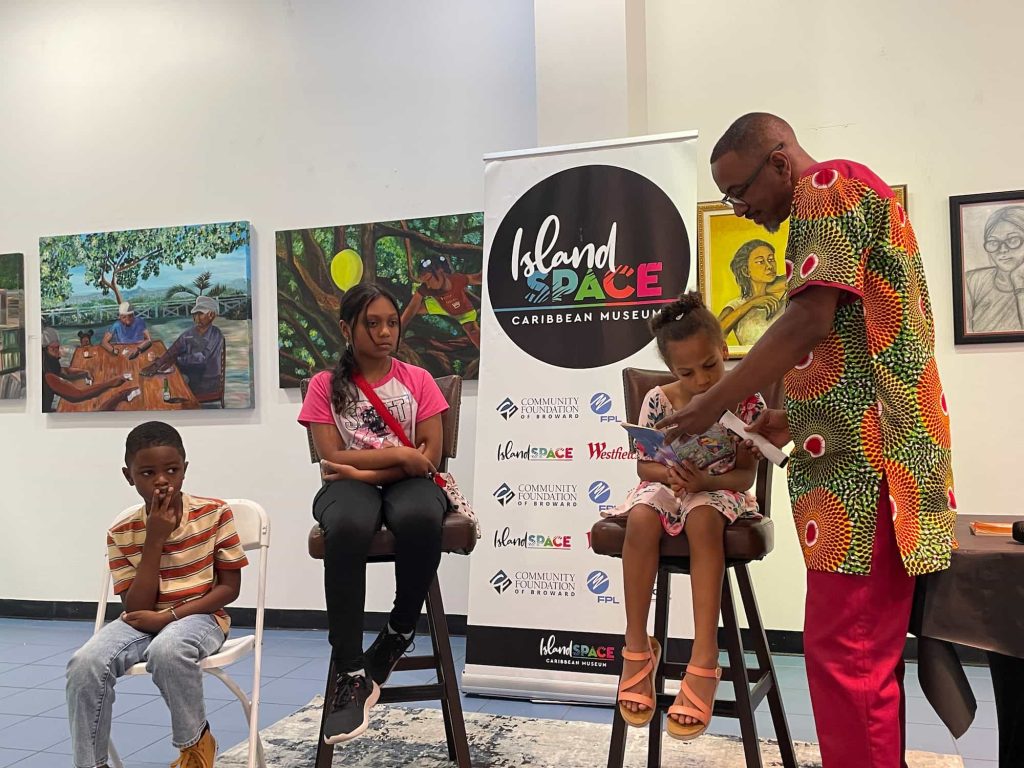 Xavier Murphy festival co-founder reading with children at the 2024 Anancy Festival