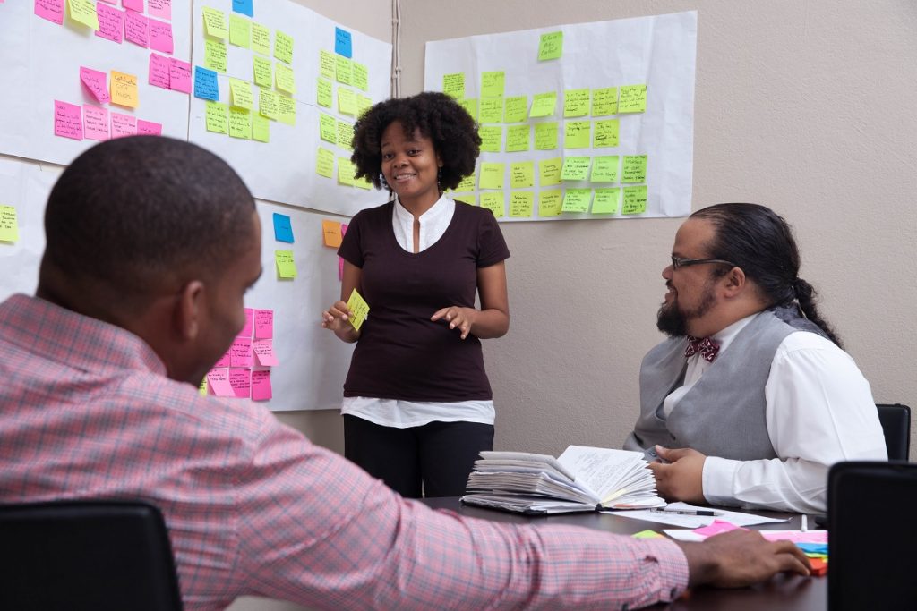 Denique Ferguson Discussing Design Research Insights with Colleagues At Slashroots