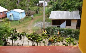 View from balcony Manchioneal with people and houses_InspiringVibes